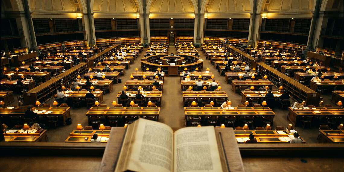 - VeyrZest.com Open book on a lectern overlooking a grand library reading room filled with desks and warm lamps.