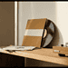 - VeyrZest.com Vinyl records leaning against a wall with a turntable on a wooden shelf, in warm light
