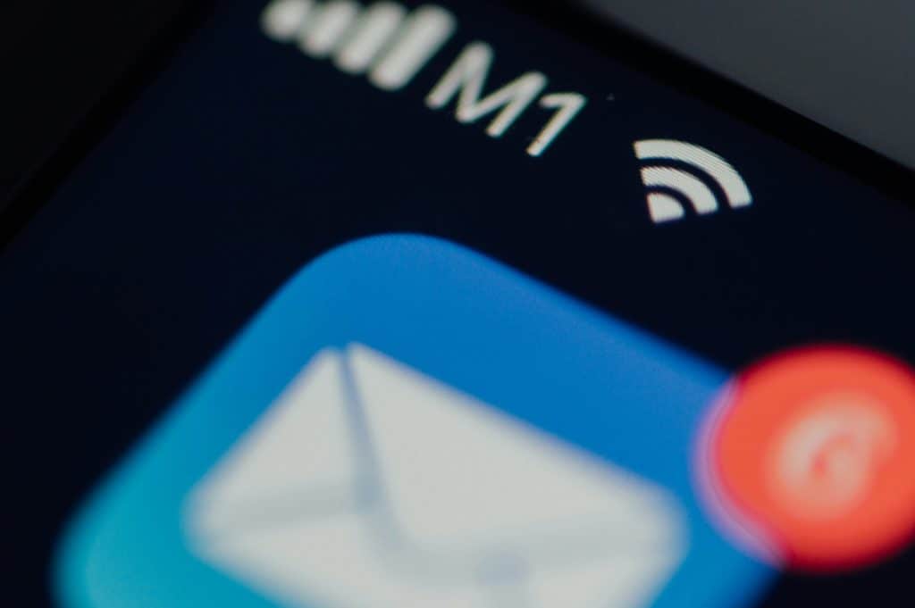 Close-up of a smartphone screen with the blue Telegram icon (paper plane) and a red notification badge, surrounded by blurred app icons.