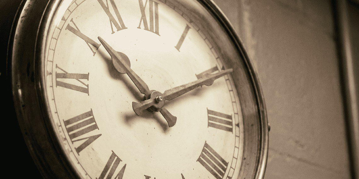 - VeyrZest.com Close-up of an antique clock face with Roman numerals and ornate hands in a sepia tone.
