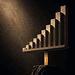 - VeyrZest.com Abstract bar chart sculpture: ascending stone blocks on a platform supported by a glowing orange pillar.