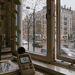 Indoor windowsill with a plant and a decibel meter reading 58 dB, looking out at a rainy city street.