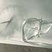 - VeyrZest.com Translucent glass liver on a stone pedestal with a blurred clock in a misty background, suggesting time and liver health.