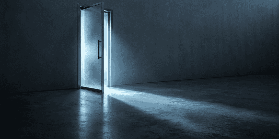 Open metal door emitting a cool blue glow into a dark, empty room.